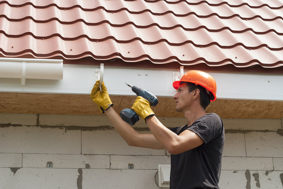 a roofing contractor installing a gutter system